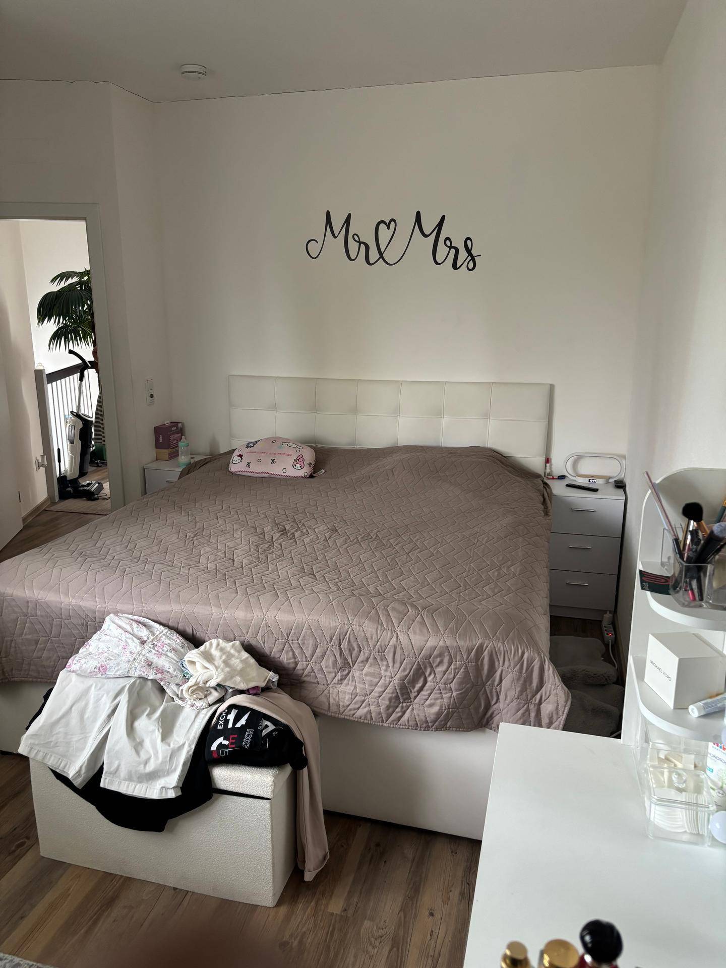 Gemütliches Schlafzimmer mit Doppelbett, Nachttischen und moderner Wanddekoration.