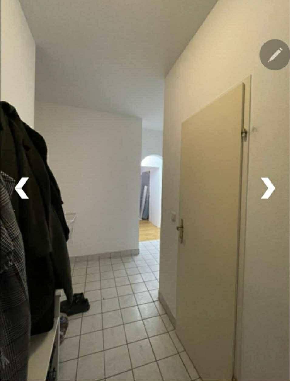 Heller Flur mit Fliesenboden und Garderobe, der zu den Wohnräumen führt.