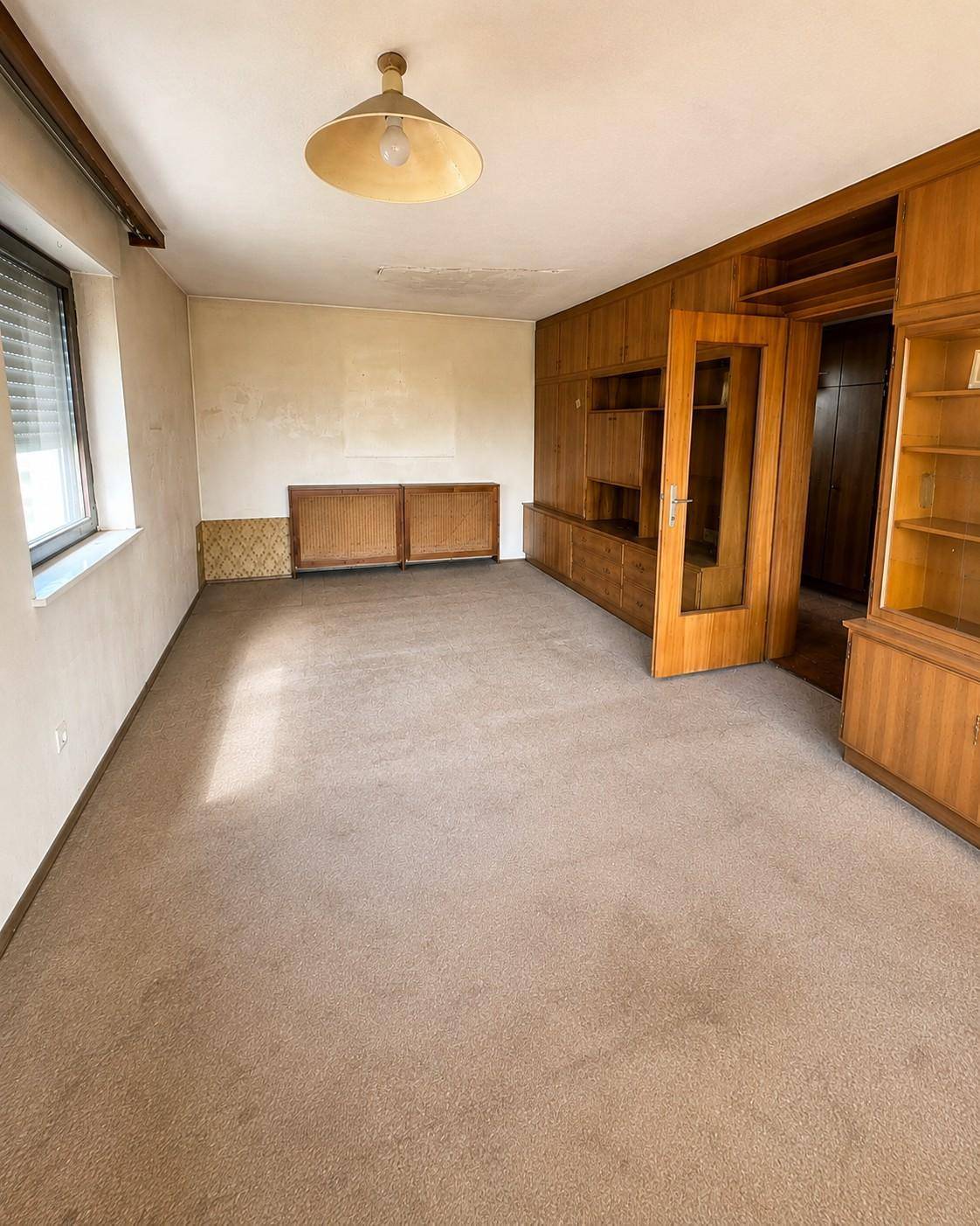 Wohnzimmer mit Teppichboden und umfangreicher Holzvertäfelung, bietet eine gemütliche Atmosphäre.
