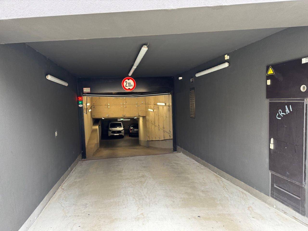 Eingang zur Tiefgarage mit Höhenbegrenzung von 2,10 Metern und dunklem Tunnel.