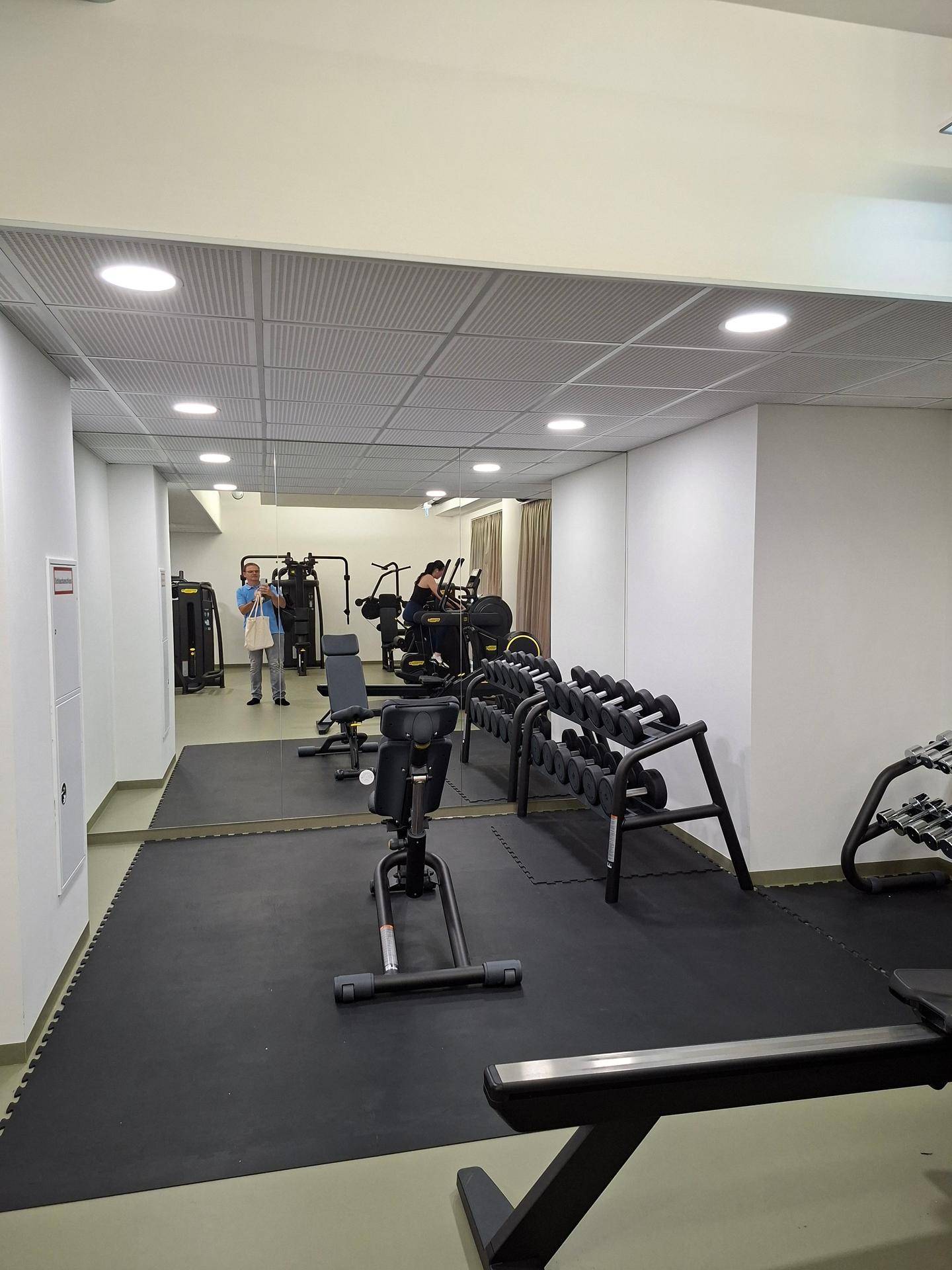 Fitnessraum mit verschiedenen Trainingsgeräten und Spiegelflächen.