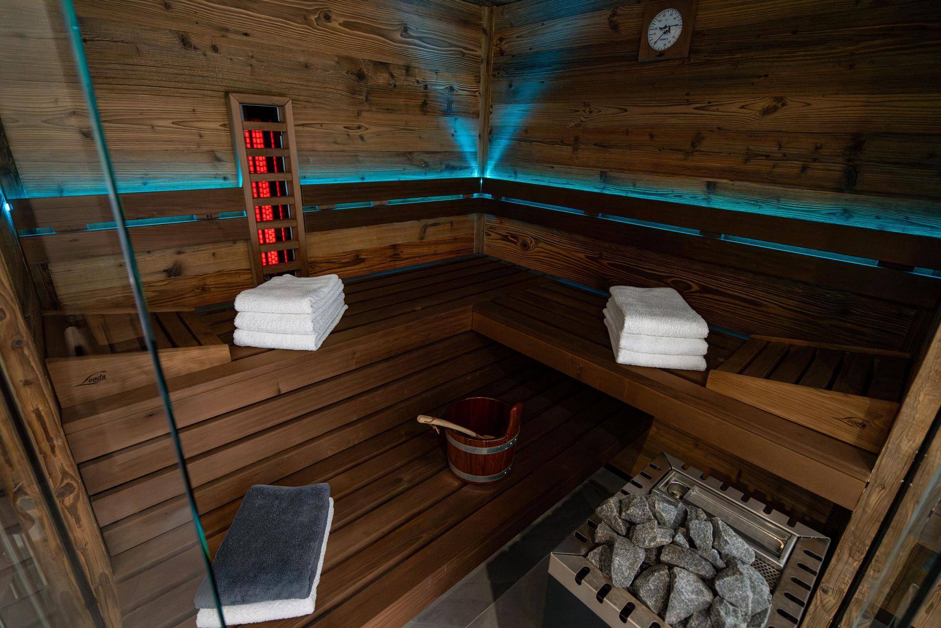Gemütliche Holzsauna mit Bänken und stimmungsvoller Beleuchtung für Entspannung.