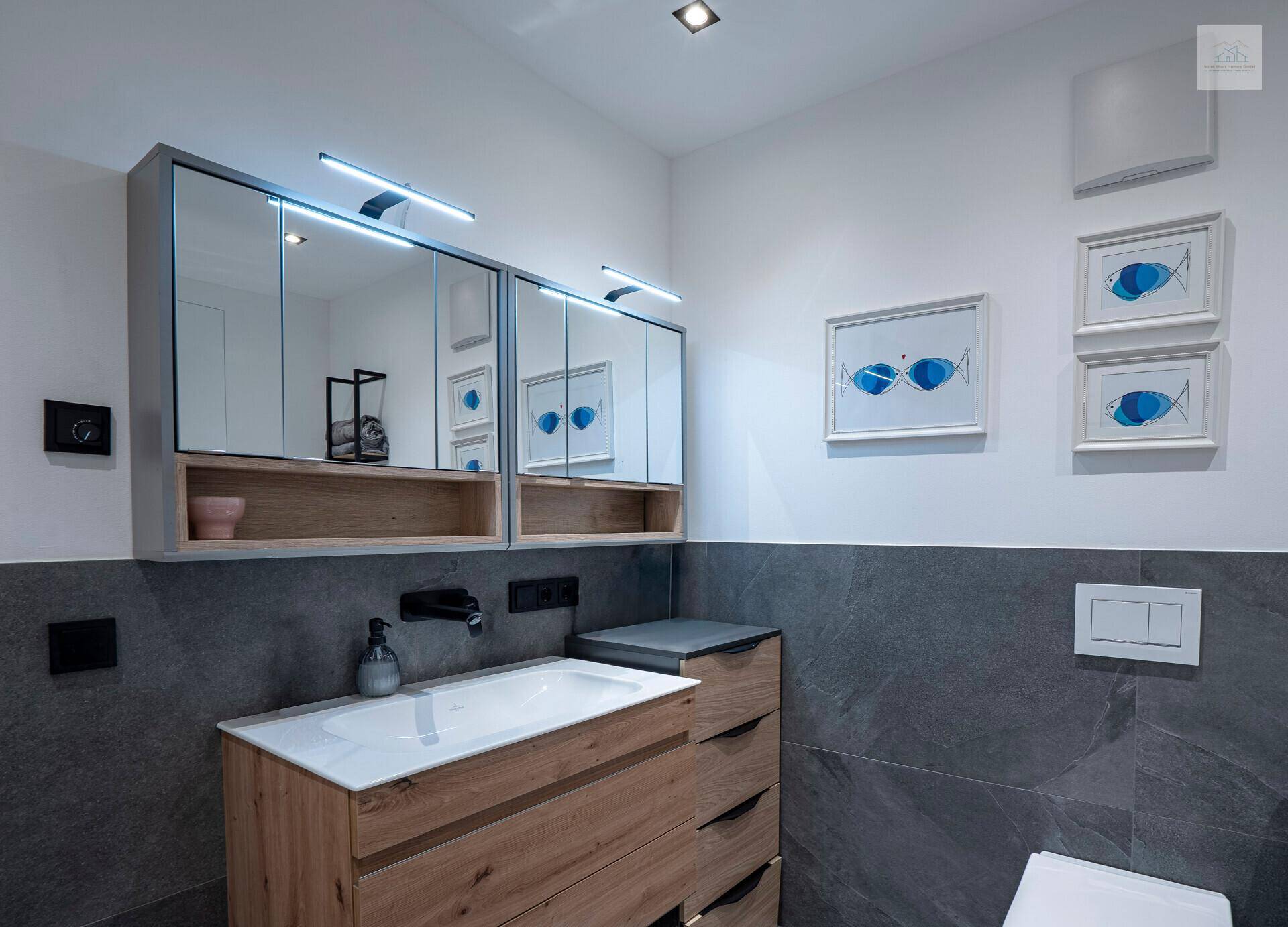 Stilvolles Badezimmer mit Holzwaschtisch, Spiegelschränken und Wand-WC.