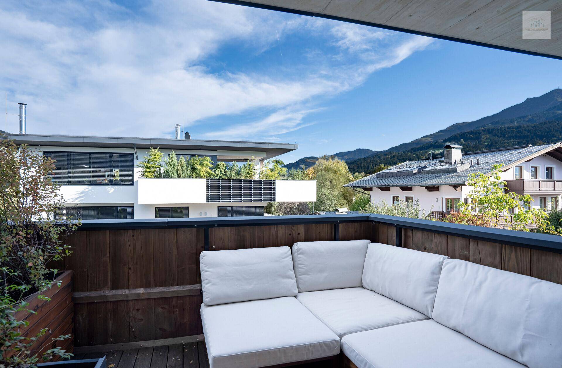 Gemütlicher Balkon mit Loungemöbeln und Panoramablick auf die umliegende Berglandschaft.