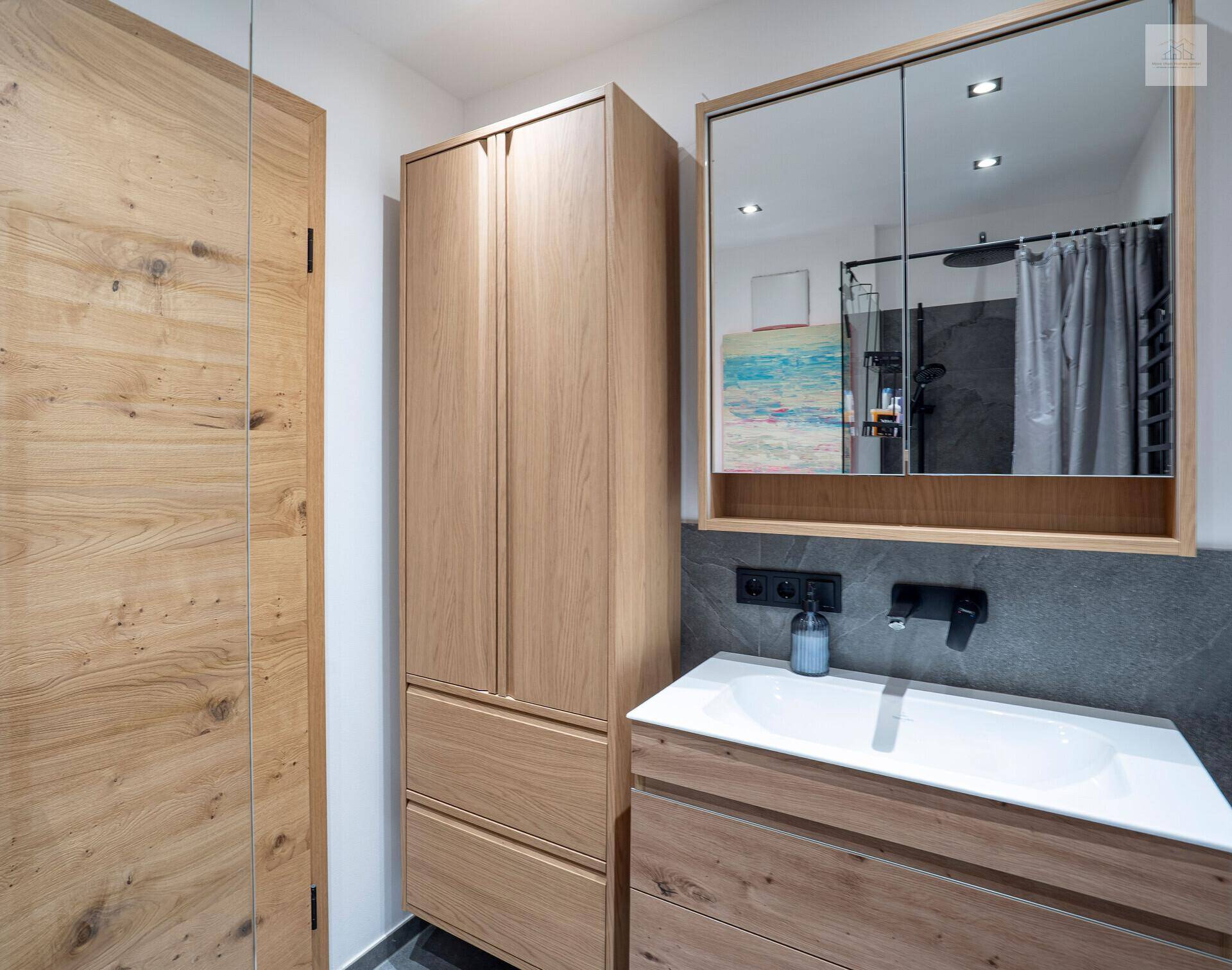 Modernes Badezimmer mit Holzmöbeln, Einzelwaschbecken und Spiegelschrank.