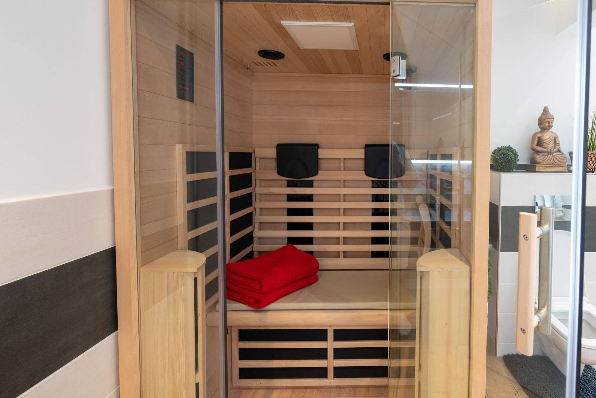 Moderne Holzsauna mit bequemen Bänken, integriert in einen stilvollen Wellnessbereich.