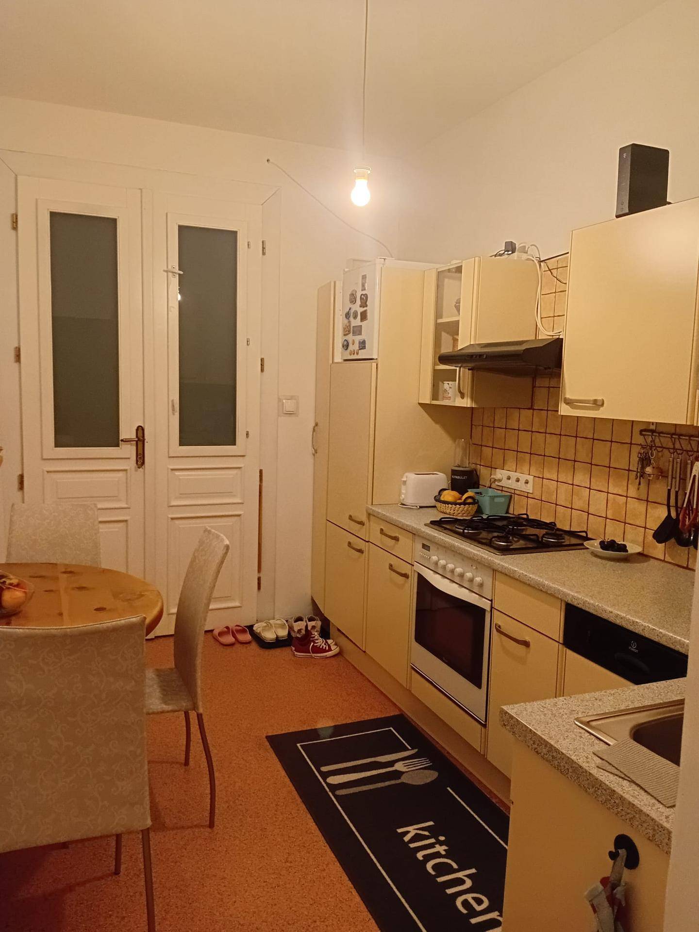 Funktionale Küche mit Essbereich, Gasherd, Backofen und beigen Schränken.