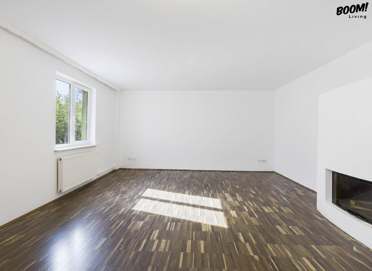 Heller Wohnraum mit Holzboden und Kamin, bereit für individuelle Einrichtungsideen.