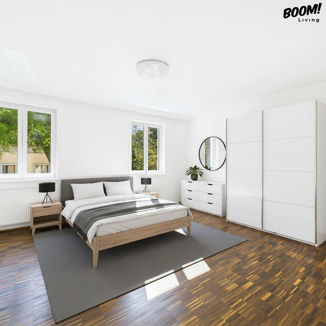 Modern eingerichtetes Schlafzimmer mit Holzboden, großem Kleiderschrank und viel Tageslicht.