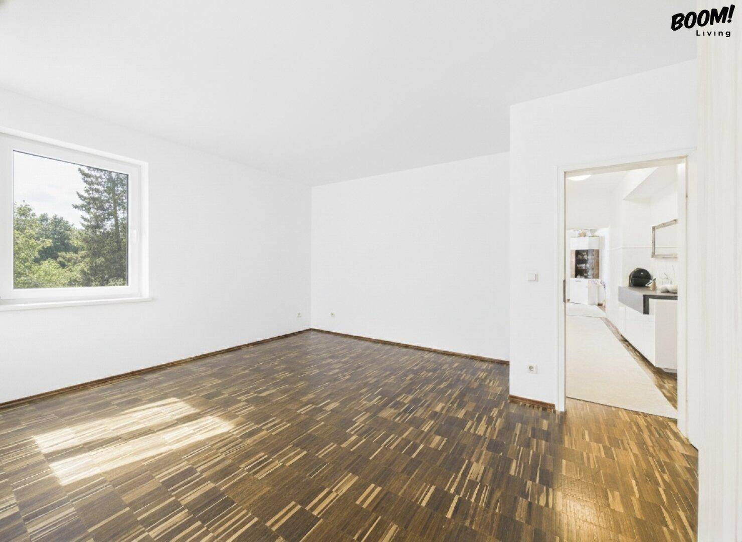 Leerer Raum mit Holzboden und großem Fenster, bietet vielseitige Gestaltungsmöglichkeiten.
