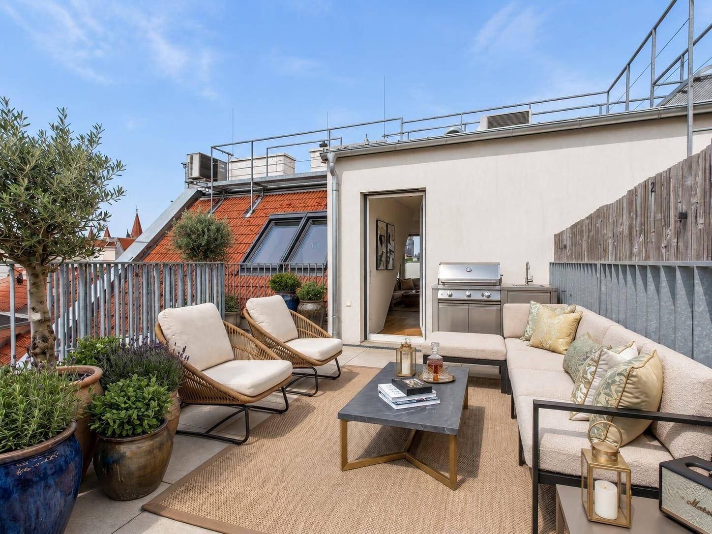 Geräumige Dachterrasse mit Lounge-Möbeln, Grillbereich und Blick über die Dächer.
