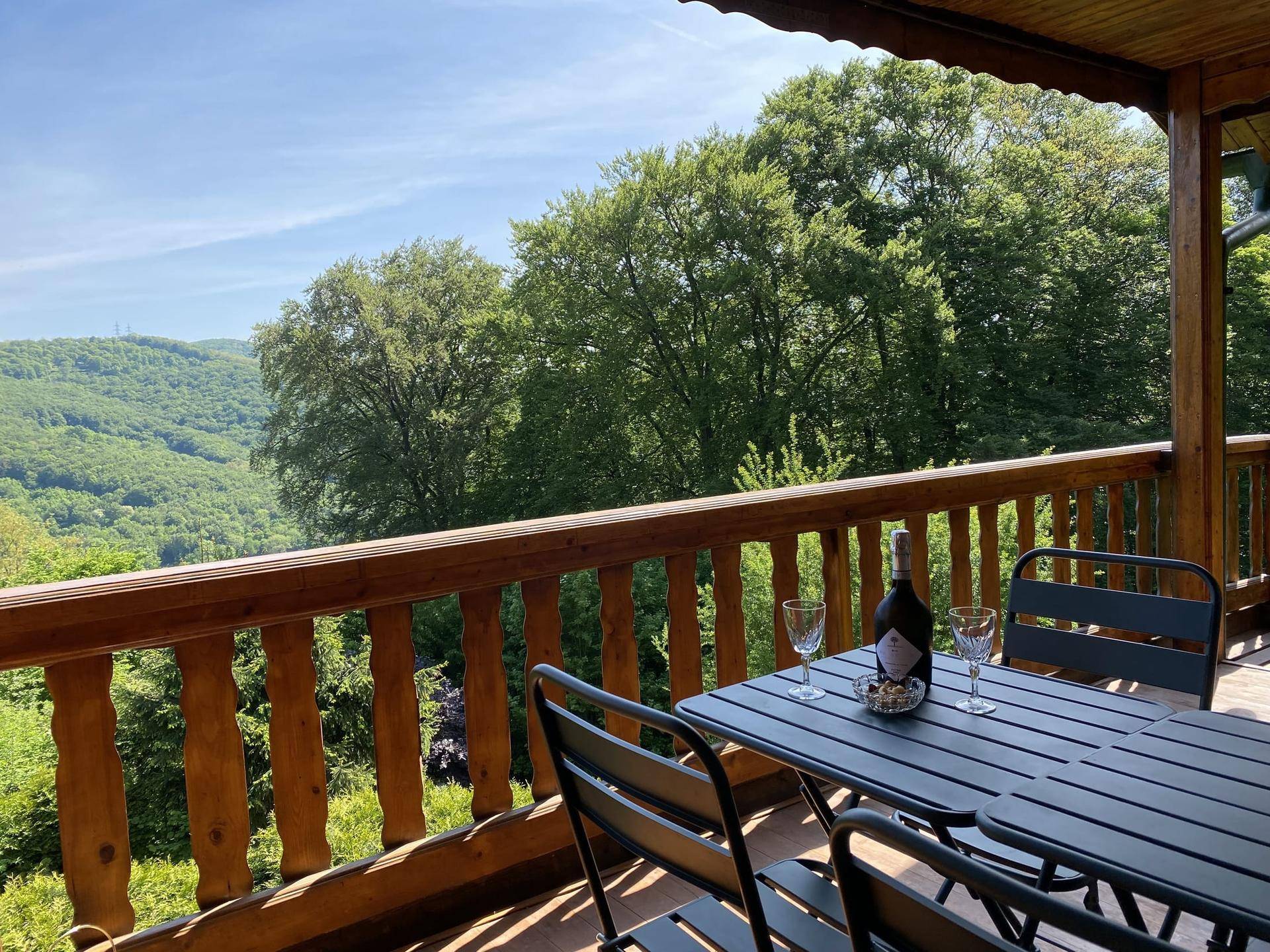 Balkon mit Holzbalken und Sitzgelegenheiten bietet einen weiten Blick ins Grüne.
