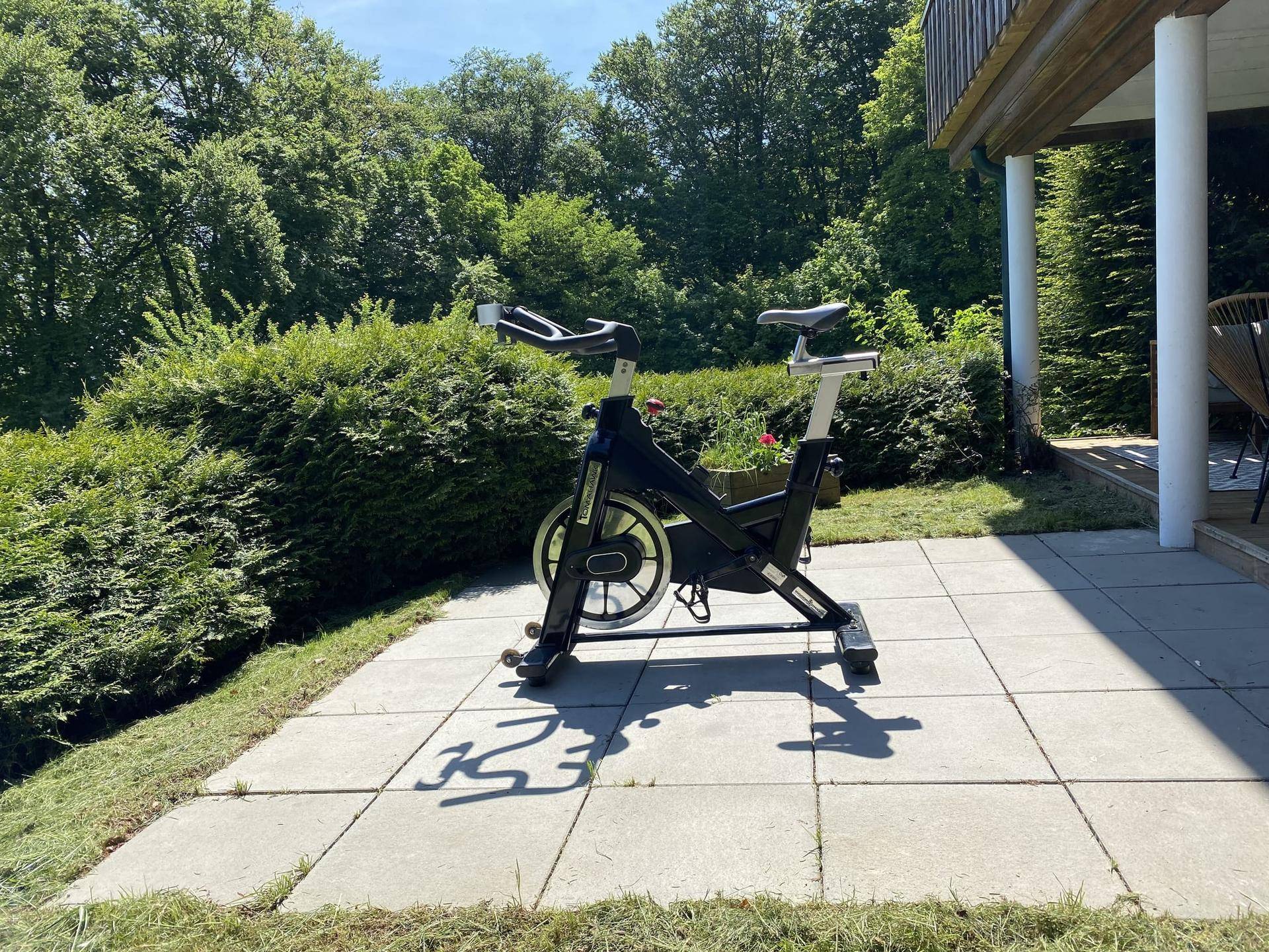 Fitnessgerät auf der Terrasse mit Blick ins Grüne an einem sonnigen Tag.