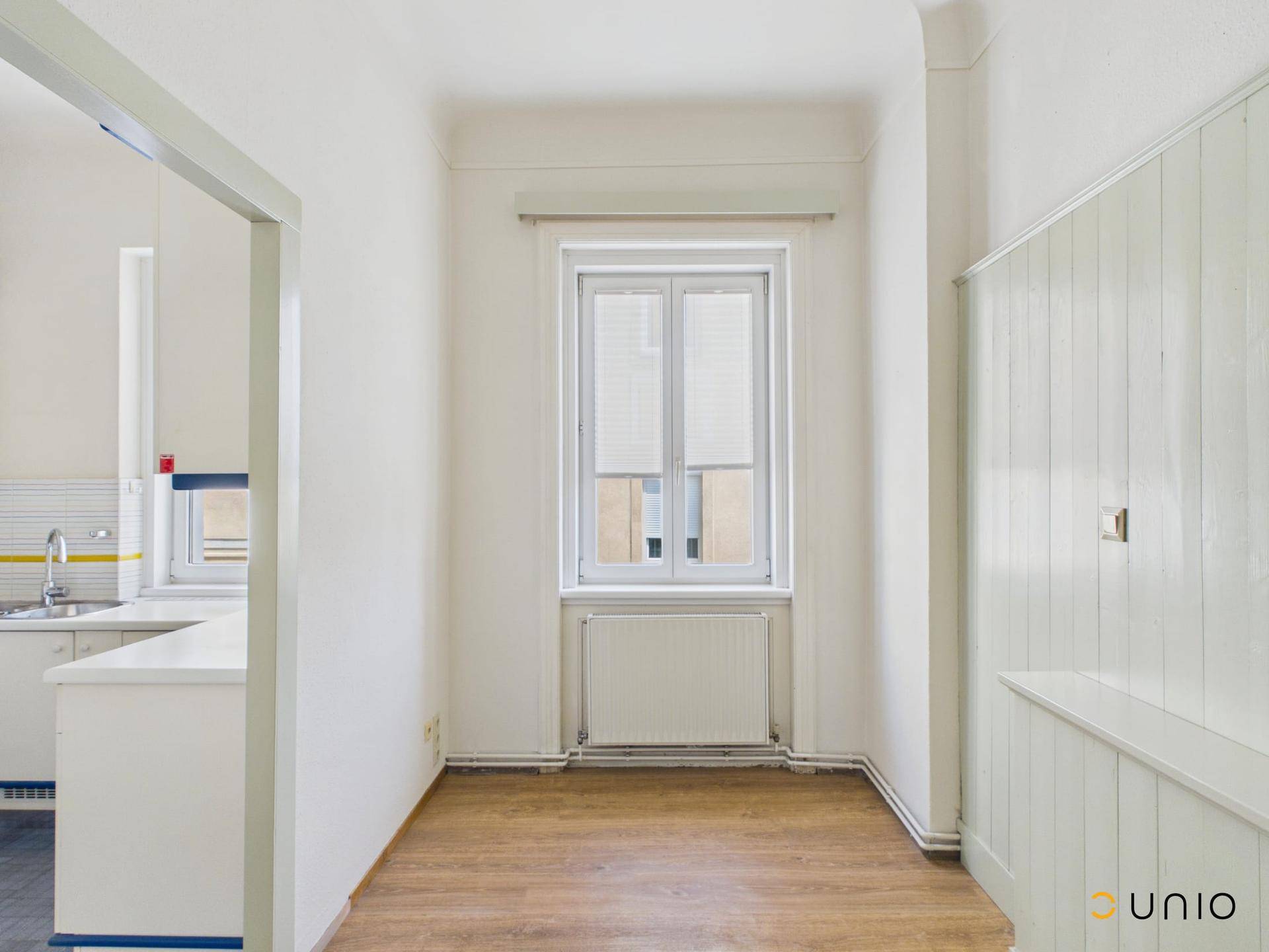 Heller Essbereich mit Fenster und Holzpaneelen, angrenzend an die Küche.