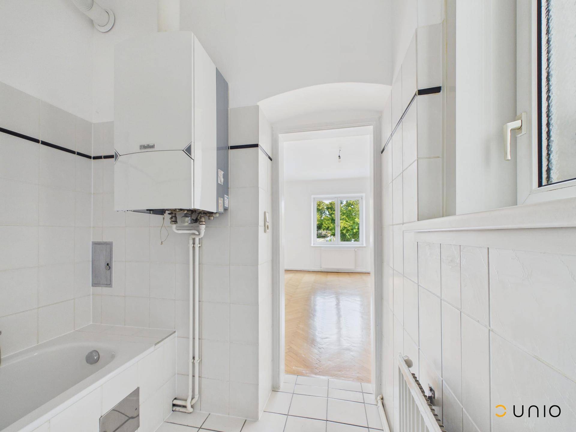 Badezimmer mit Badewanne, Gastherme und Fenster, bietet Potenzial zur Neugestaltung.