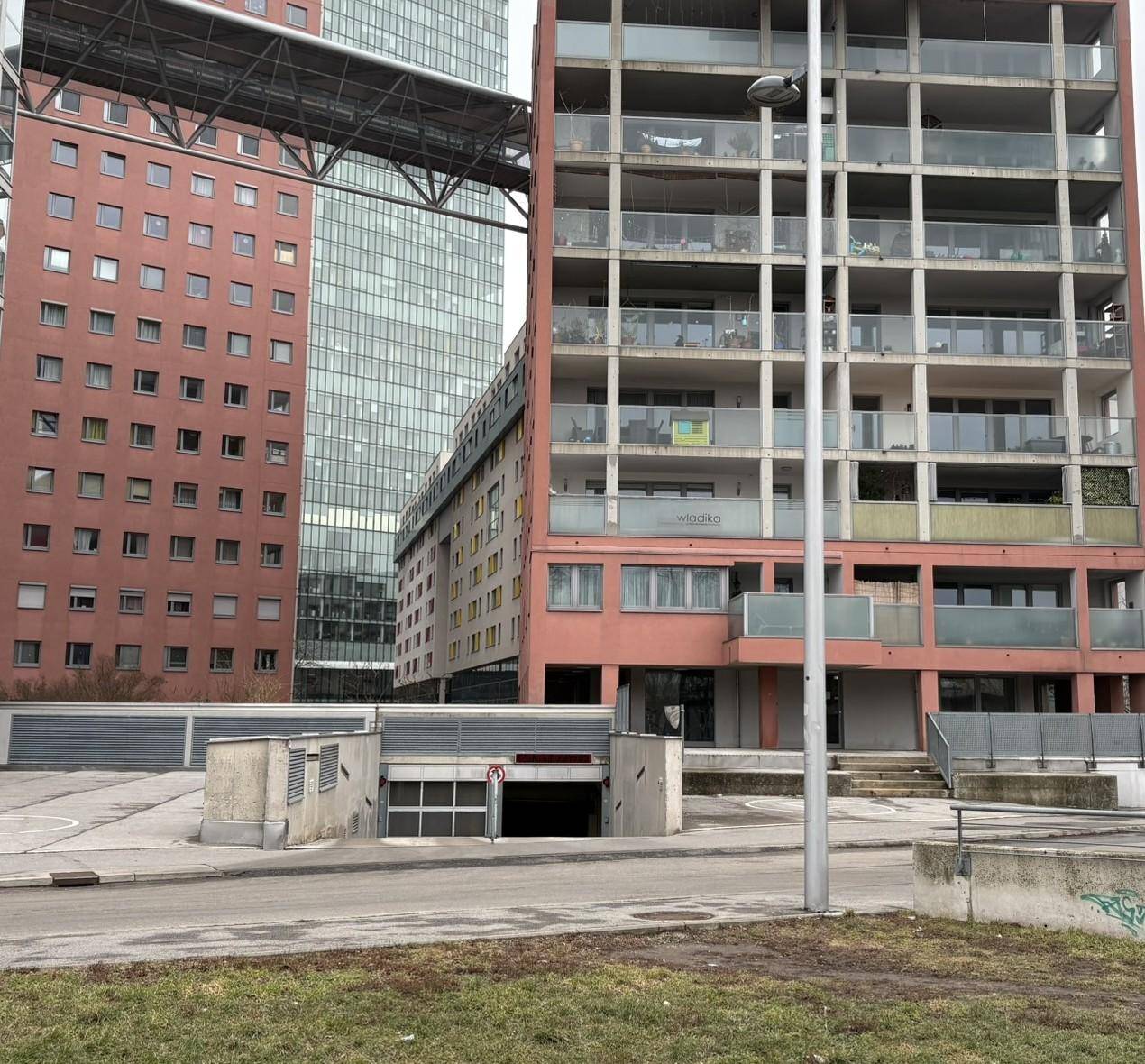 Moderne Wohngebäude in urbaner Umgebung mit Zugang zur Tiefgarage und zeitgenössischer Architektur.