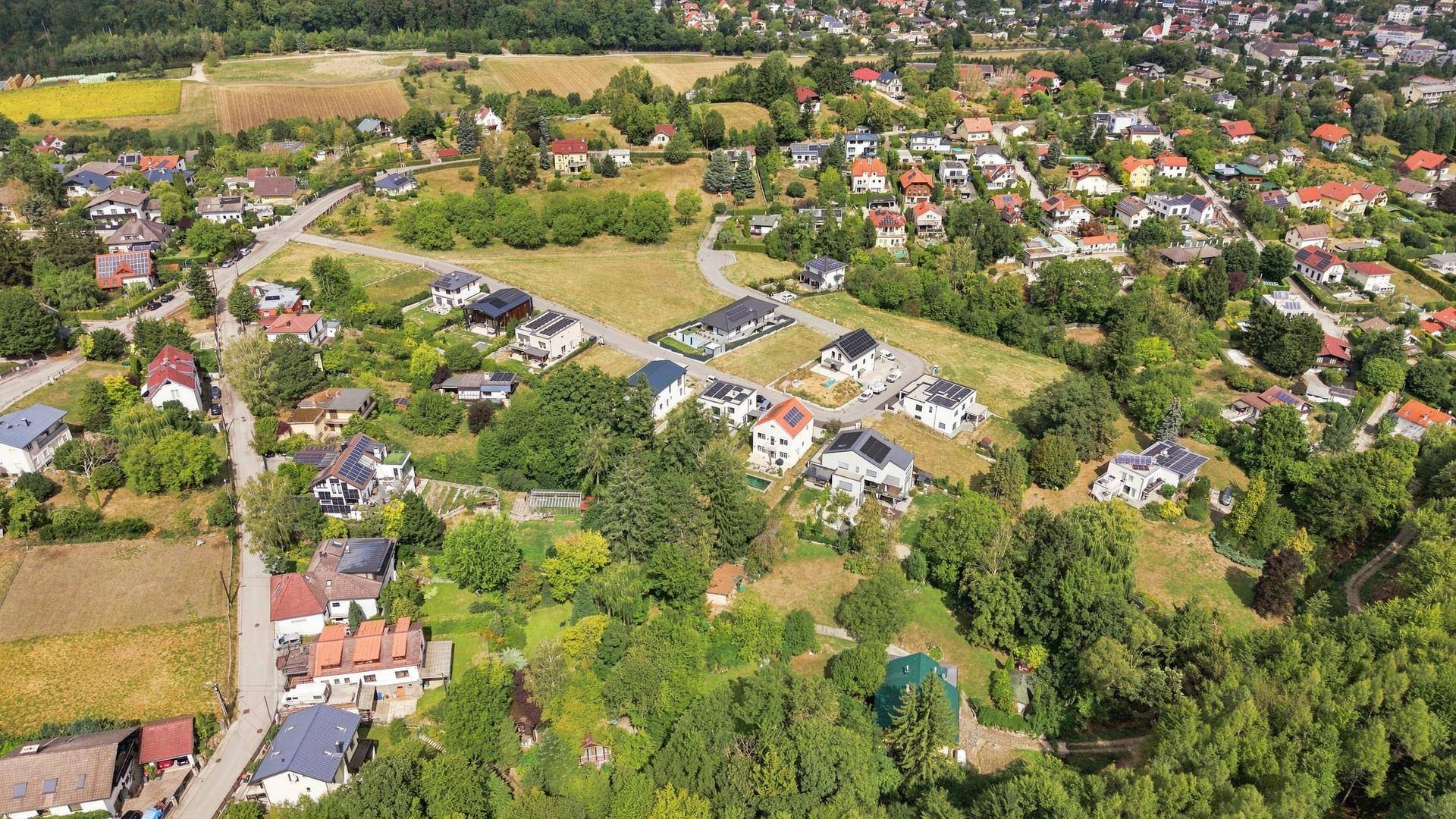Luftaufnahme einer Wohnsiedlung mit Häusern und viel Grün in ländlicher Umgebung.