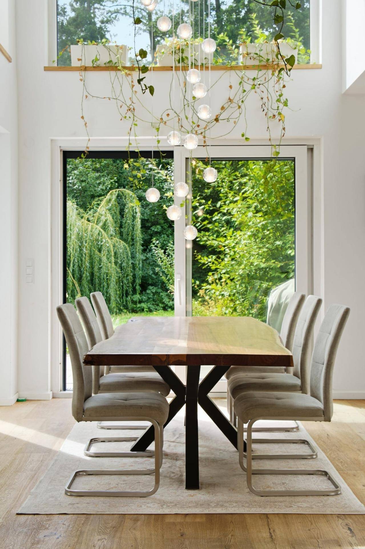 Lichtdurchfluteter Essbereich mit Holztisch, bequemen Stühlen und Gartenblick.