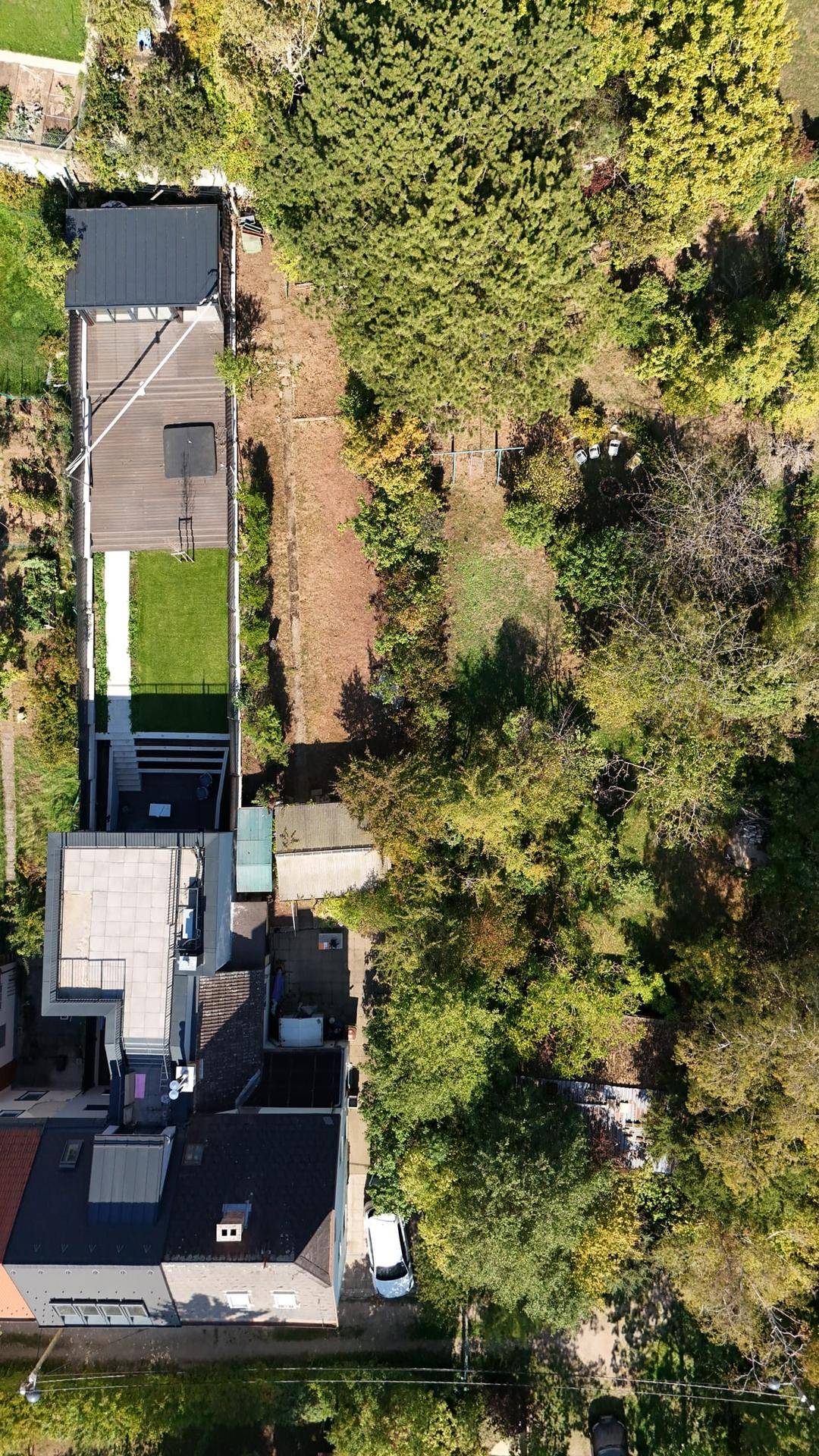 Vertikale Luftaufnahme des Grundstücks mit Garten, Terrasse und umliegender Bebauung.