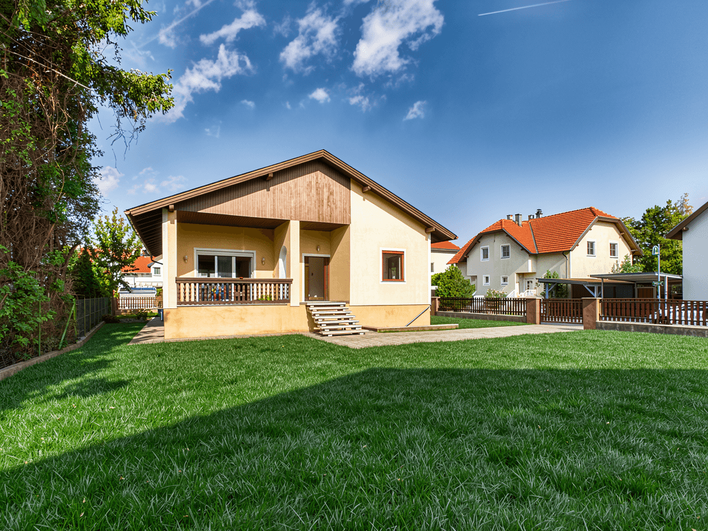 Gepflegter Garten mit großer Rasenfläche und Blick auf das Einfamilienhaus.