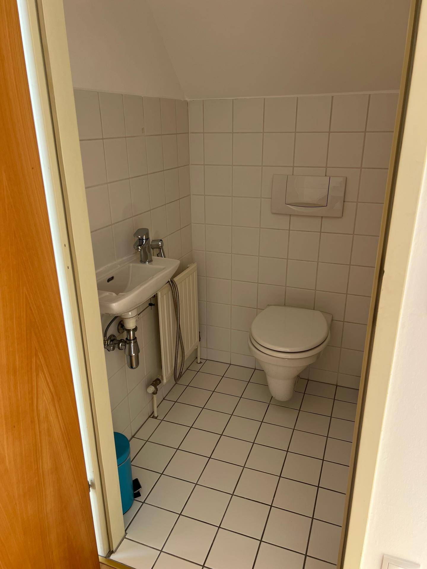 Kleines Gäste-WC mit Toilette und Waschbecken, vollständig gefliest.
