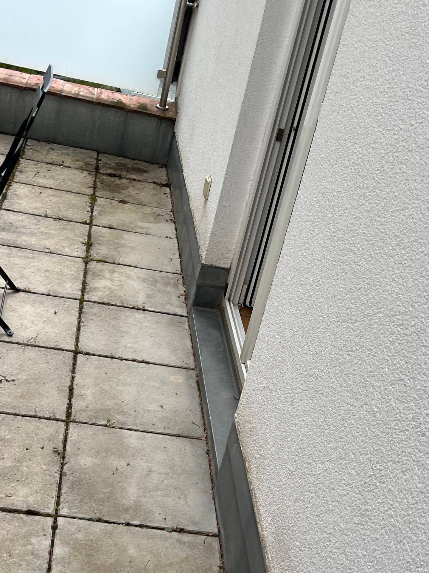 Gedeckte Terrasse mit Fliesenboden und Zugang zum Innenbereich durch eine Schiebetür.