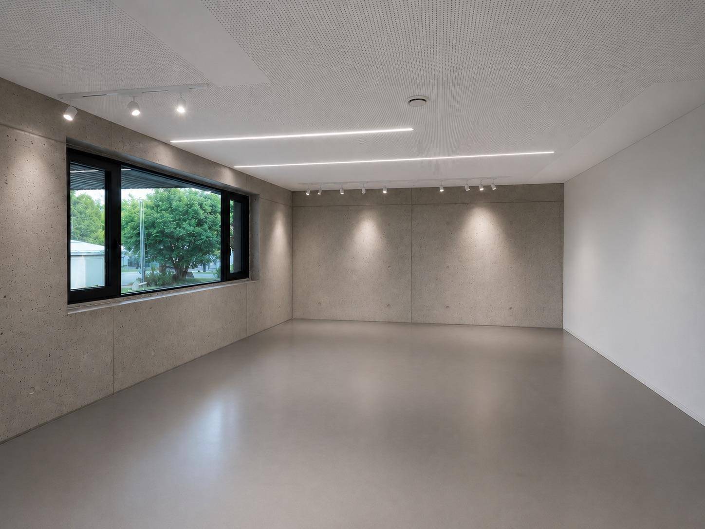 Moderner Raum mit Sichtbetonwänden, Betonboden, integrierter Beleuchtung und Fenster mit Grünblick.