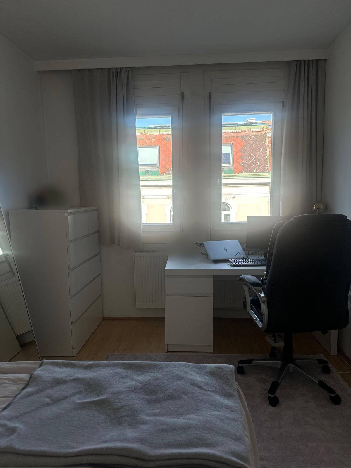 Helles Arbeitszimmer mit Schreibtisch, Bürostuhl und Fenster, ideal für Home-Office.