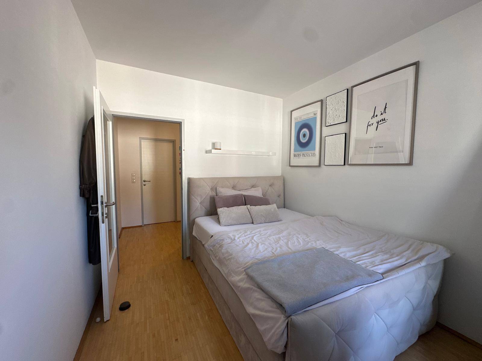 Kleines Schlafzimmer mit Einzelbett, Holzboden und moderner Wanddekoration.