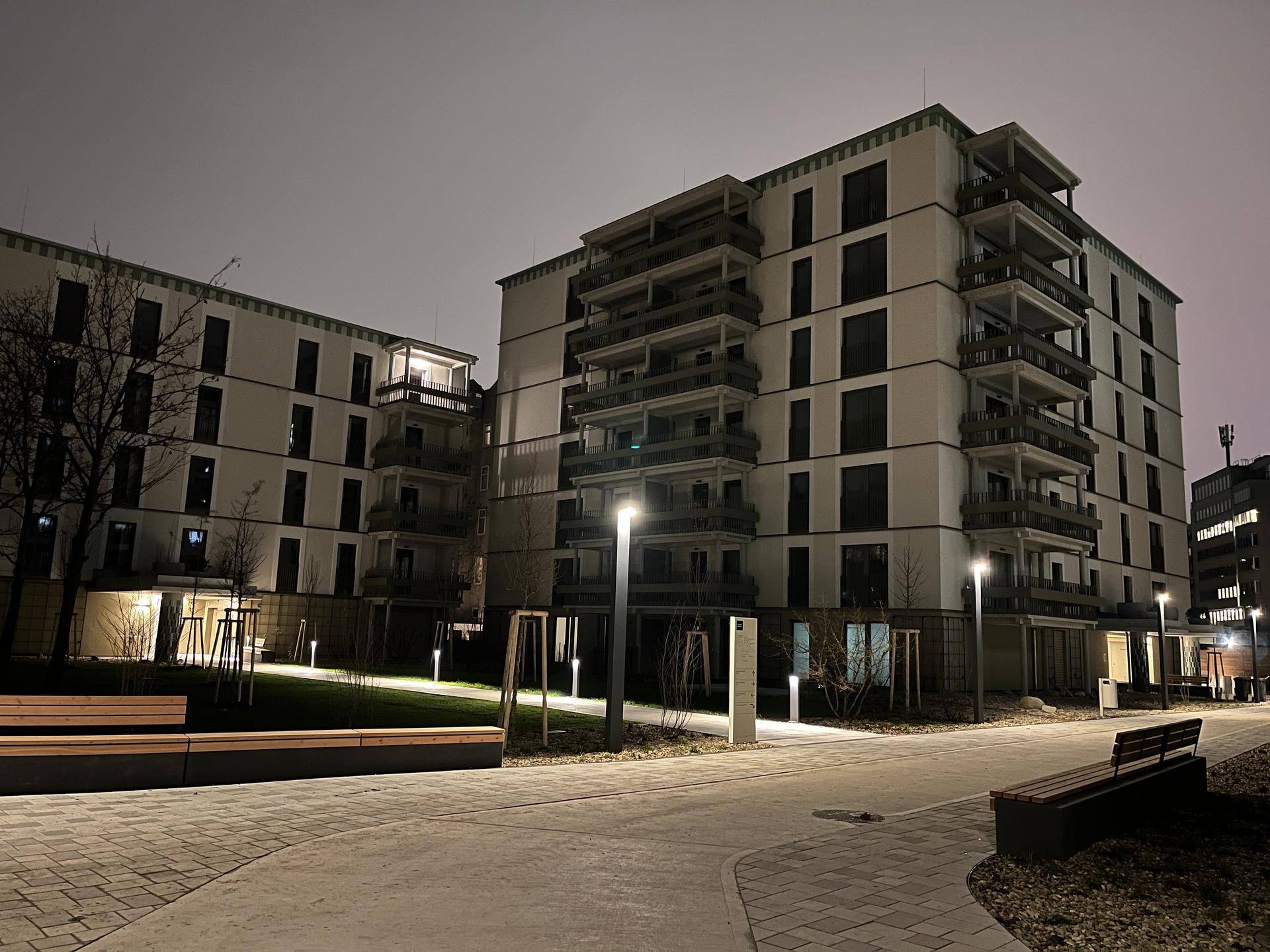 Moderne Wohngebäude bei Nacht, beleuchtet von stilvollen Außenleuchten in der Anlage.