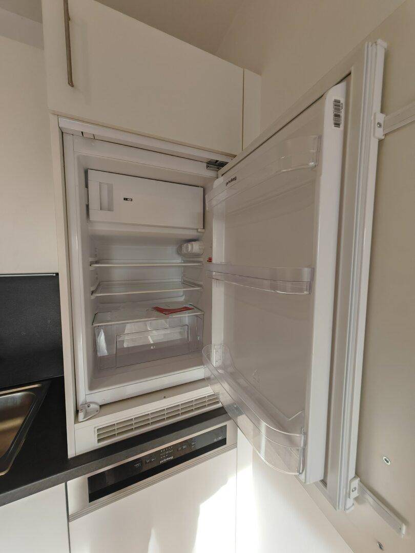 Offener Einbaukühlschrank mit Gefrierfach, bietet Stauraum für Lebensmittel.