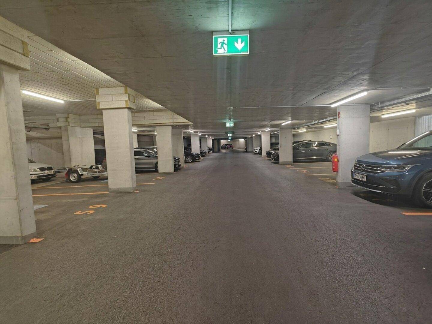 Geräumige Tiefgarage mit vielen Stellplätzen und klarer Beschilderung.