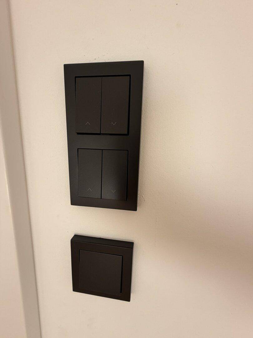 Moderne schwarze Lichtschalter an einer weißen Wand, ein Detail der Innenausstattung.