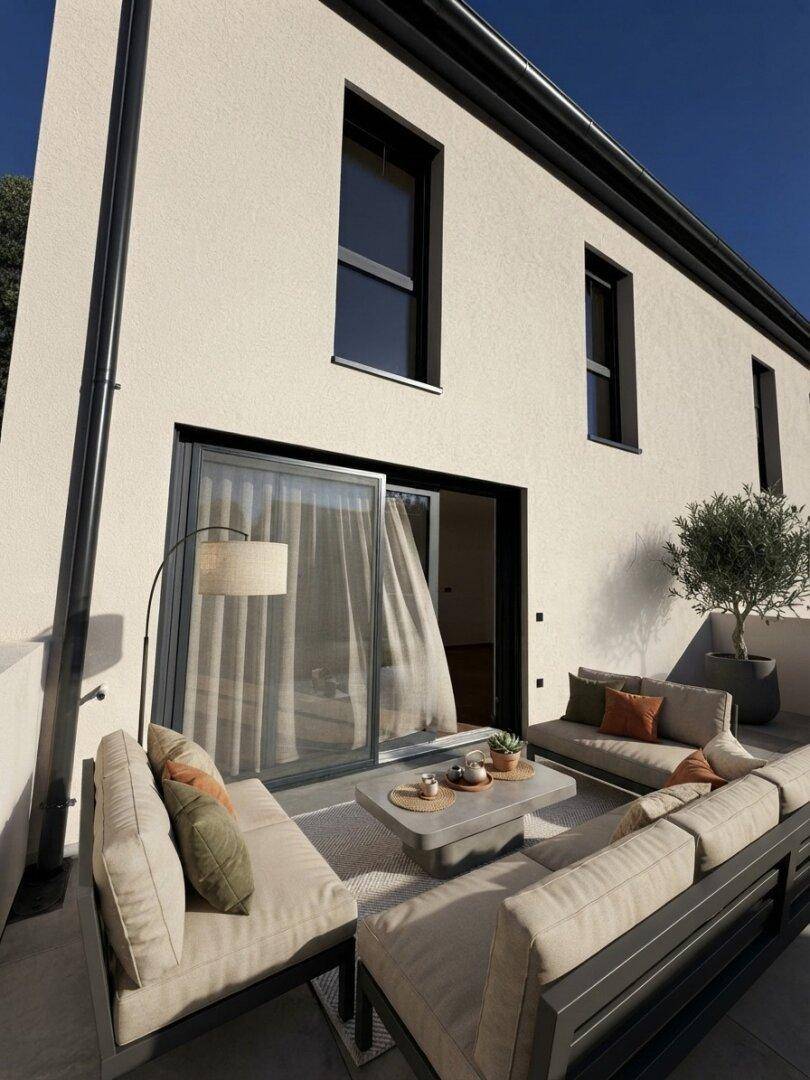 Stilvolle Terrasse mit modernen Loungemöbeln und großzügiger Schiebetür zum Innenbereich.