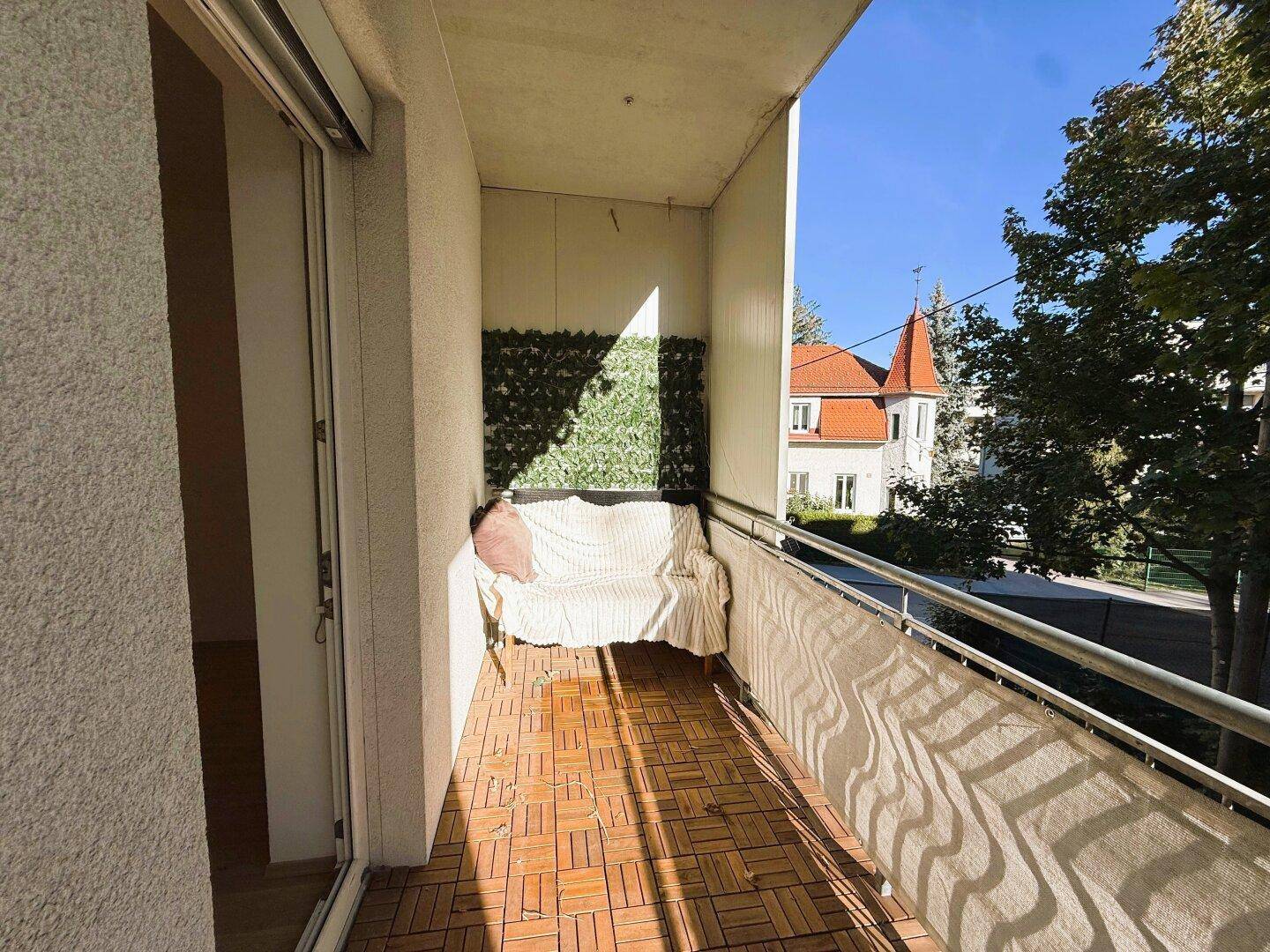 Gemütlicher Balkon mit Sitzgelegenheit und Blick auf die Umgebung, teilweise begrünt.
