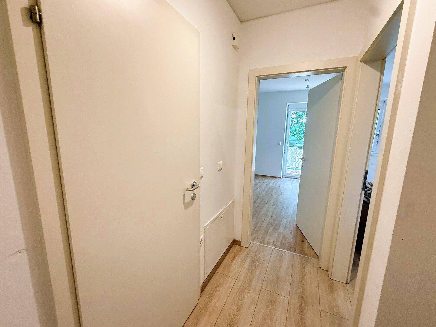 Heller Flur mit Holzboden und Türen zu den angrenzenden Zimmern der Wohnung.