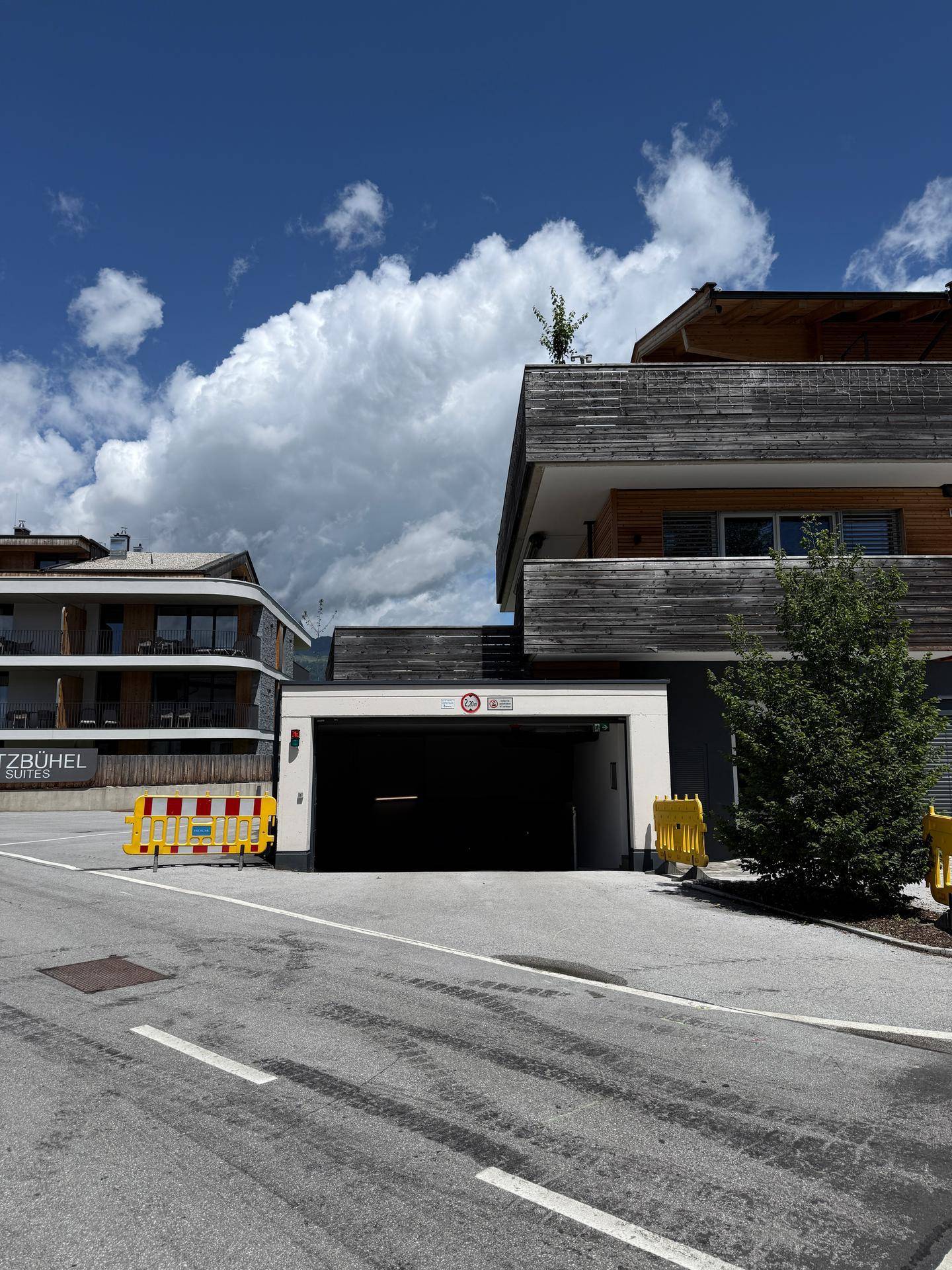 Modernes Gebäude mit Tiefgarageneinfahrt von der Straße aus gesehen.