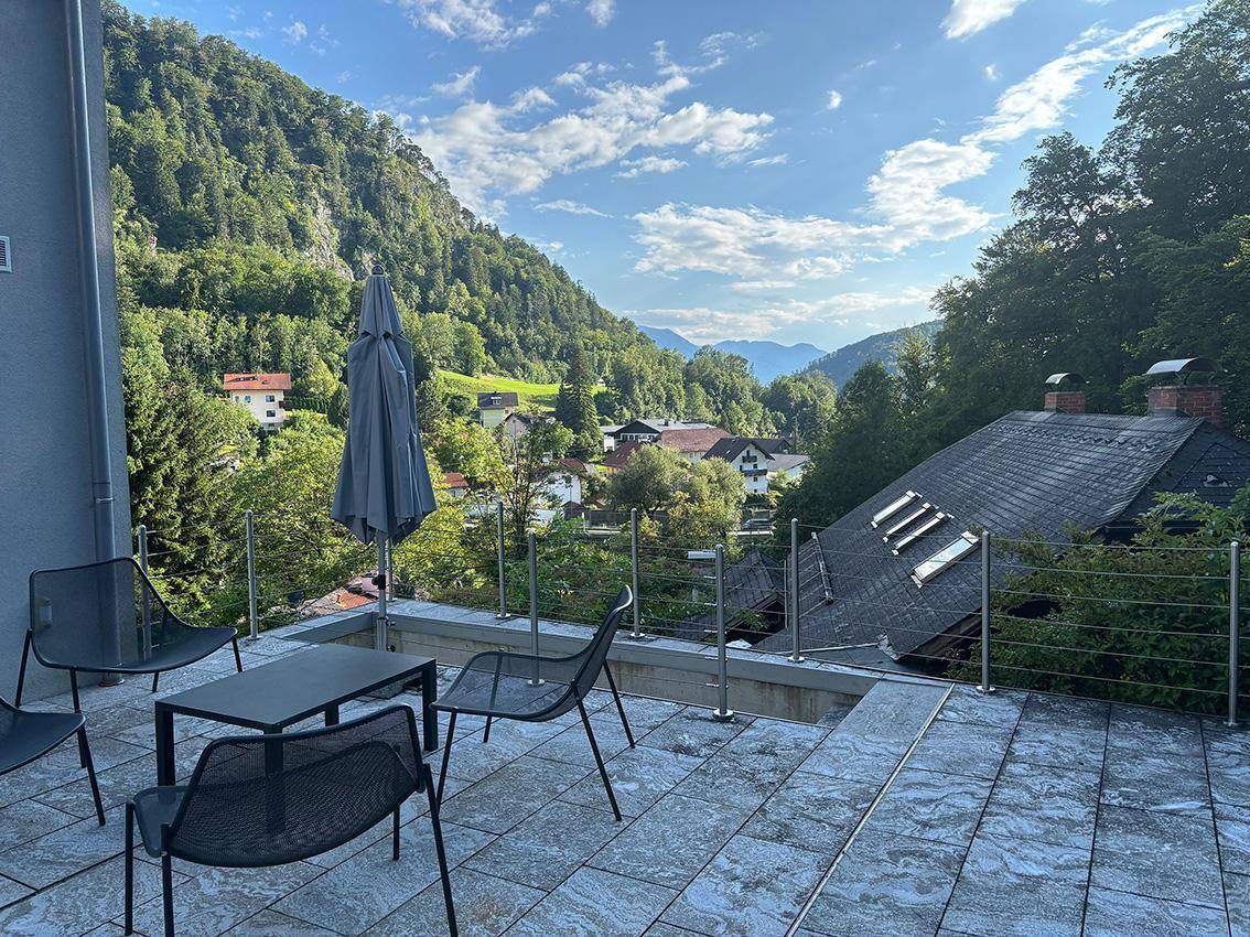 Geräumige Terrasse mit modernen Gartenmöbeln und einem atemberaubenden Panoramablick auf die umliegende Berglandschaft.