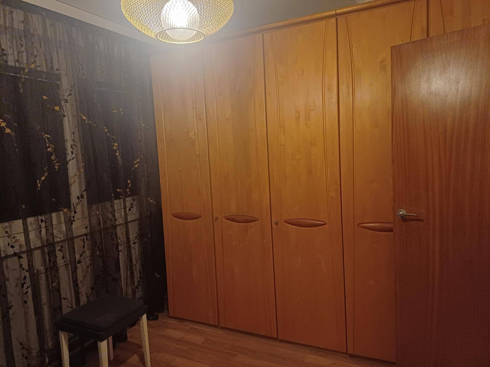 Schlafzimmer mit großem, hellem Holzschrank und passendem Holzboden, bietet viel Stauraum.