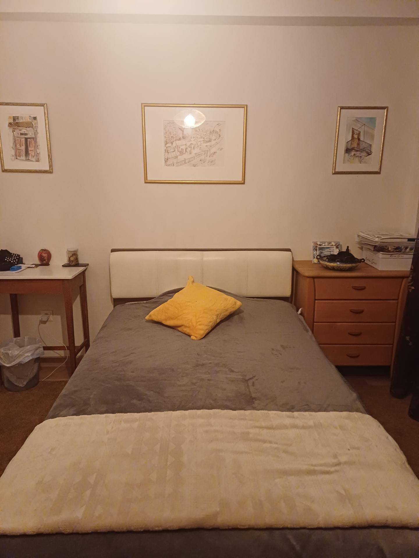 Gemütliches Schlafzimmer mit Doppelbett, Nachttischen und gerahmten Bildern an den Wänden.