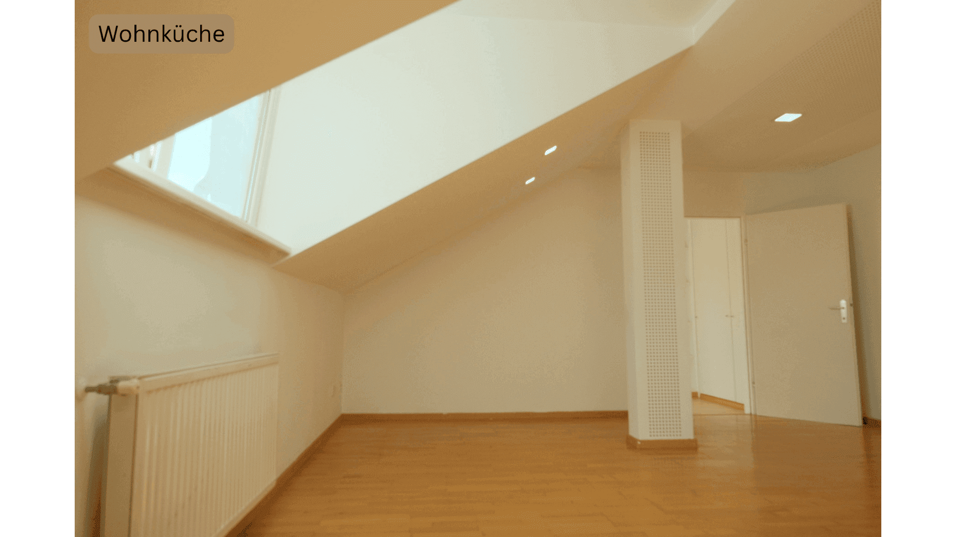 Heller Dachgeschossraum mit Fenster, Heizkörper und schrägen Wänden, bereit zur individuellen Gestaltung.