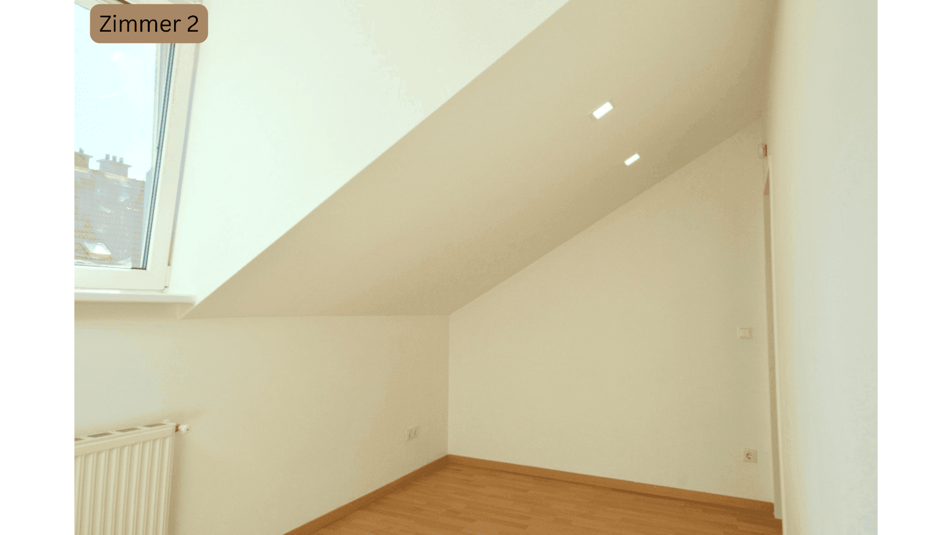 Geräumiges Schlafzimmer im Dachgeschoss mit Holzboden und schrägen Wänden.