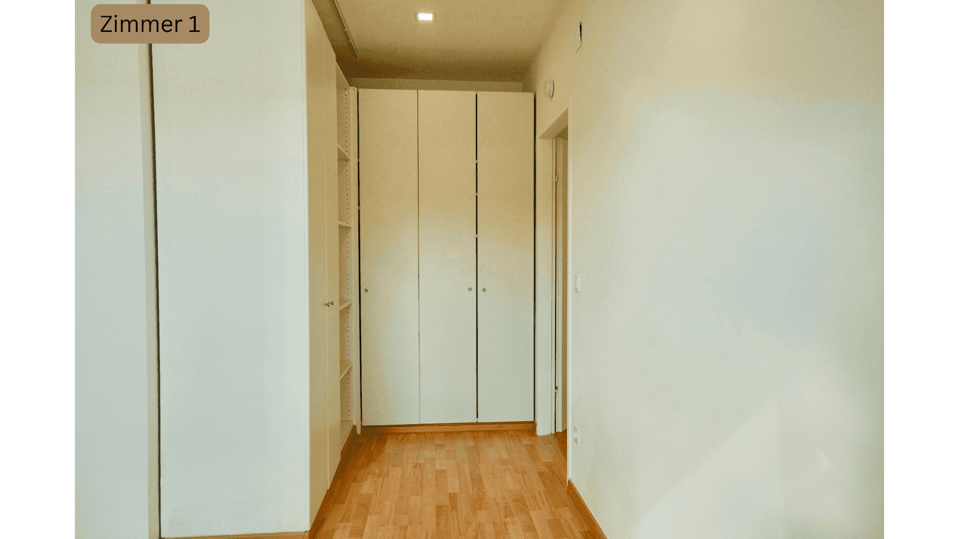 Schlafzimmer im Dachgeschoss mit praktischen Einbauschränken und Holzboden.
