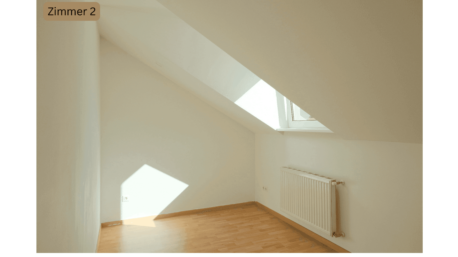 Helles Schlafzimmer im Dachgeschoss mit schrägen Wänden, Fenster und Holzboden.