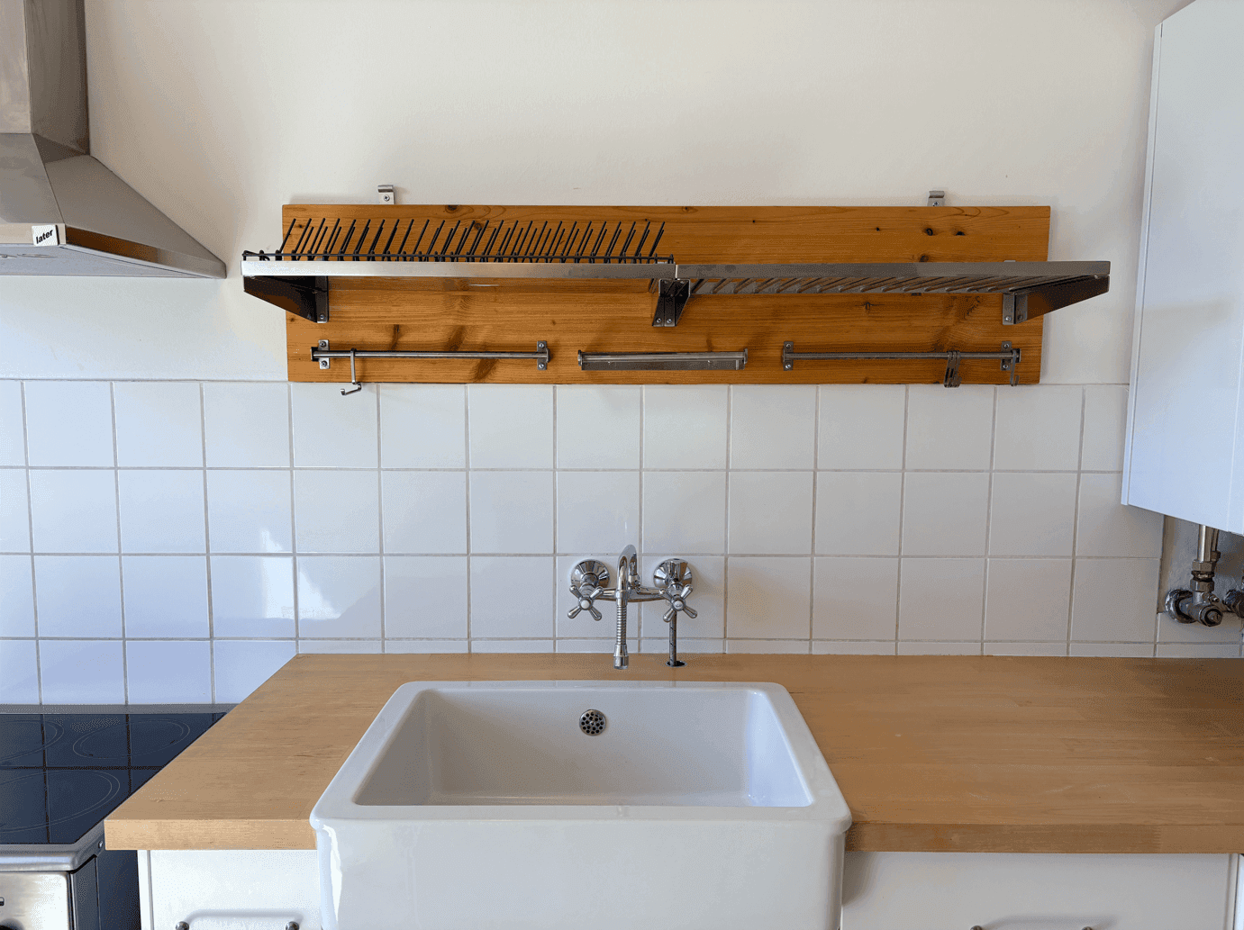 Detailansicht des Küchenbereichs mit Holz-Arbeitsplatte, weißem Spülbecken und praktischem Abtropfgestell.