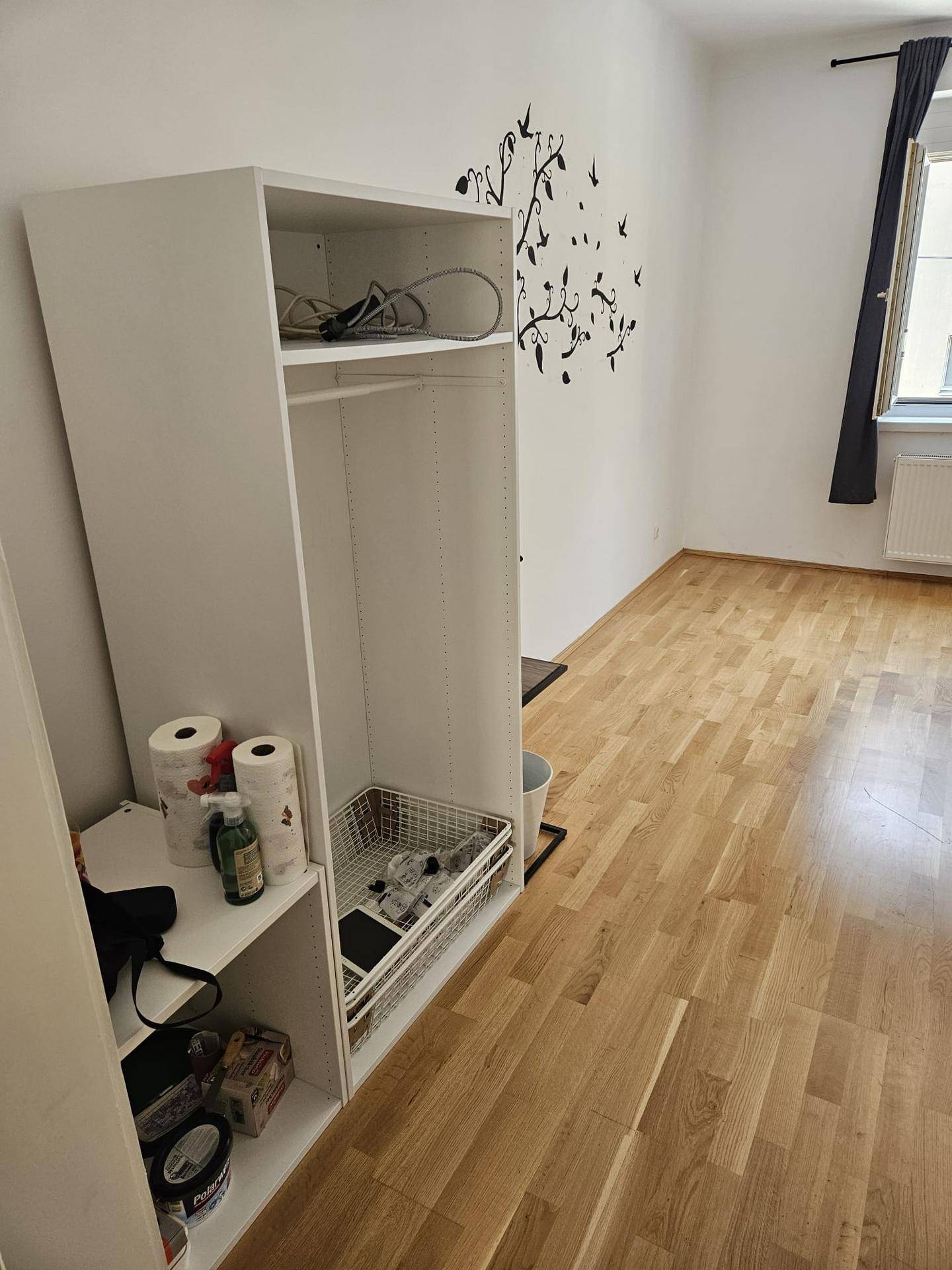 Schlafzimmer mit Holzboden und offenem Kleiderschrank, bereit zur Einrichtung.