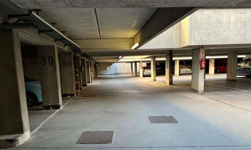 Geräumige Tiefgarage mit nummerierten Stellplätzen und solider Betonkonstruktion, gut beleuchtet.