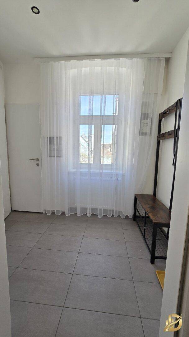 Heller Eingangsbereich mit Fliesenboden und Fenster, bietet Platz für Garderobe.