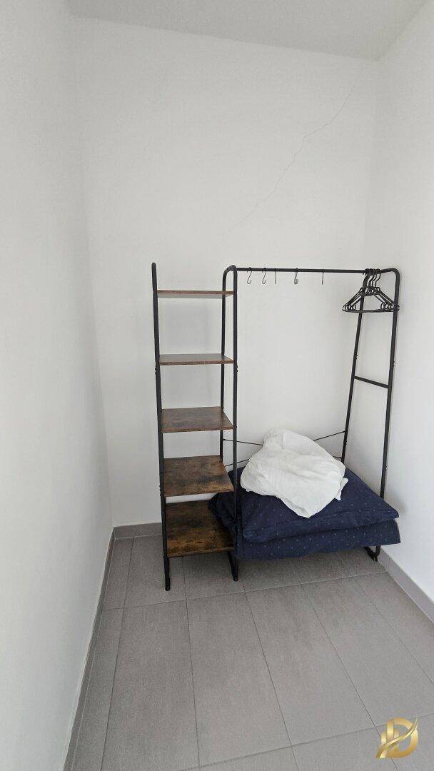 Praktischer Abstellraum mit Regalen und Kleiderstange, ideal für zusätzlichen Stauraum.