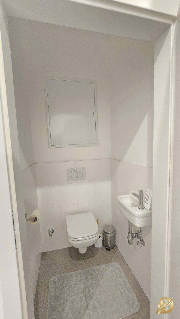 Kleines separates WC mit Toilette und Handwaschbecken, praktisch und funktional.